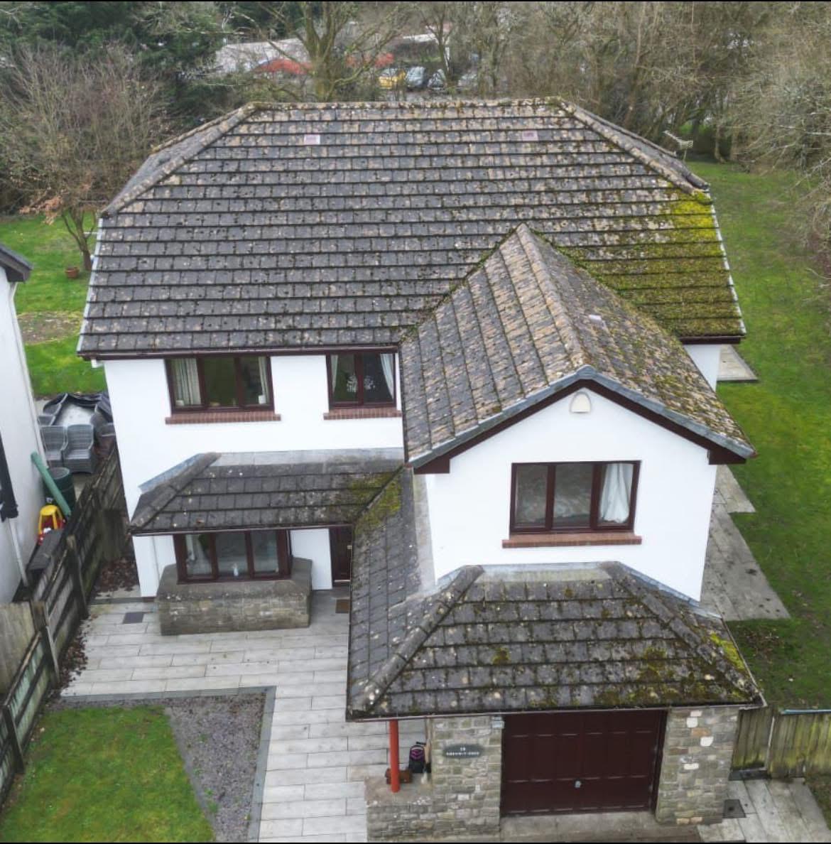 Aerial before shot of a moss-heavy pitched roof in South Wales